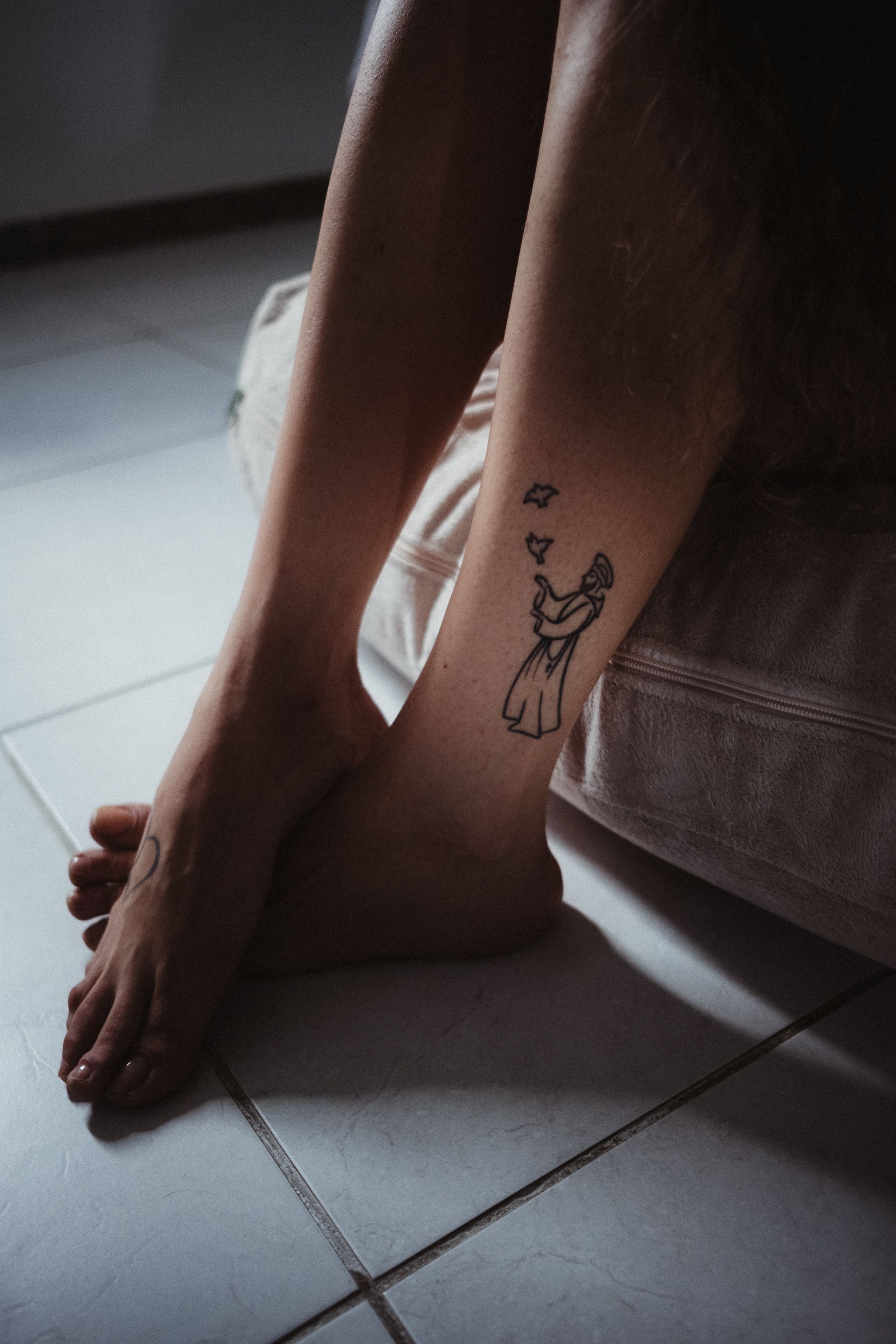 Tatuagem delicada floral no braço feminino